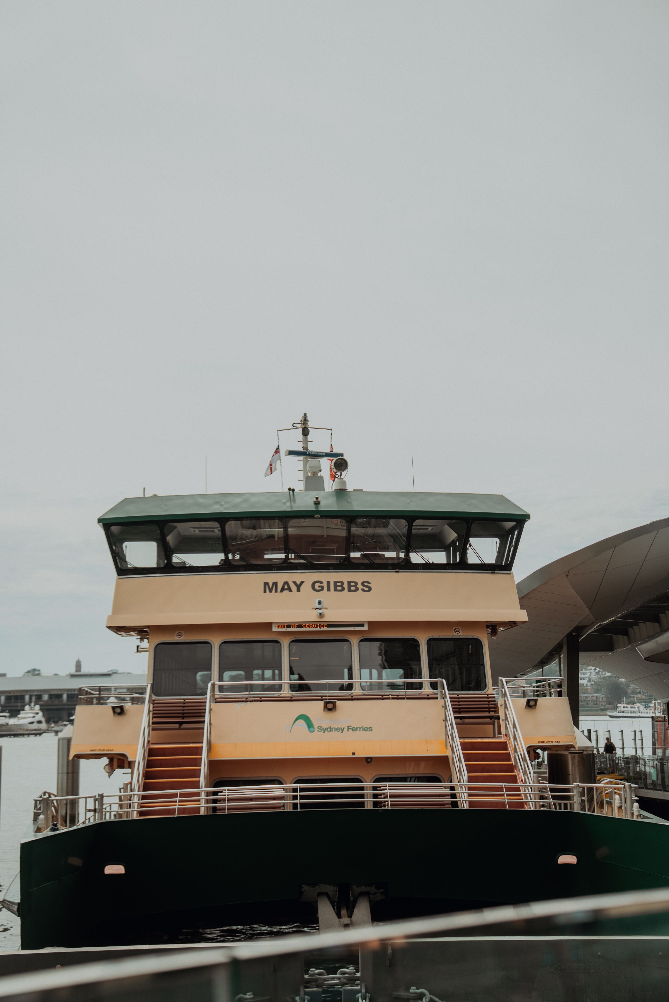 Front view of the Sydney Ferry "May Gibbs" docked at a wharf. Overcast day.