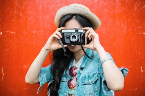 Wanita Dengan Jaket Denim Biru Memegang Kamera Hitam