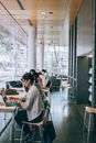 Pensive woman using laptop in modern library