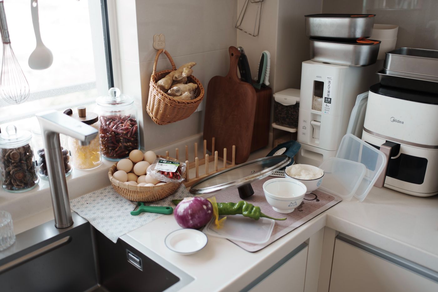 Real home kitchen counter arranged for food preparation with an air fryer and fresh ingredients