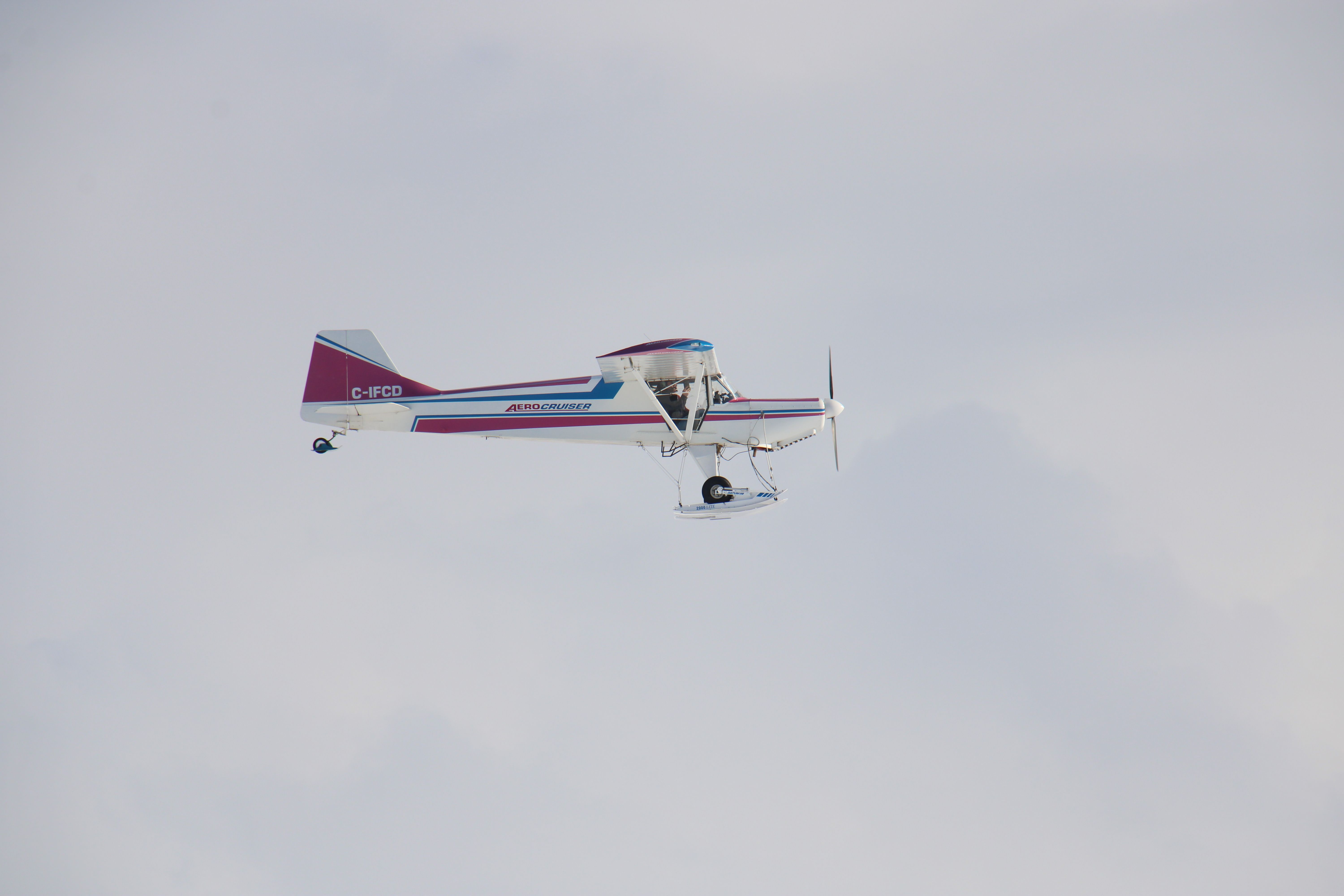 A single-engine aircraft soaring in a clear cloudy sky, perfect for aviation themes.