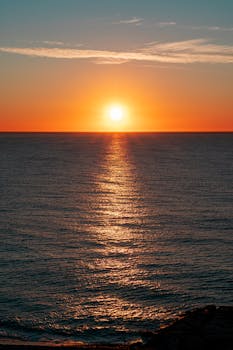 A captivating sunset over the ocean with golden light reflecting on the water surface.