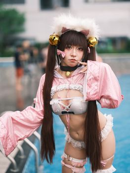 Vibrant cosplay photo at a Vietnam event, capturing a woman in pink costume by the pool.