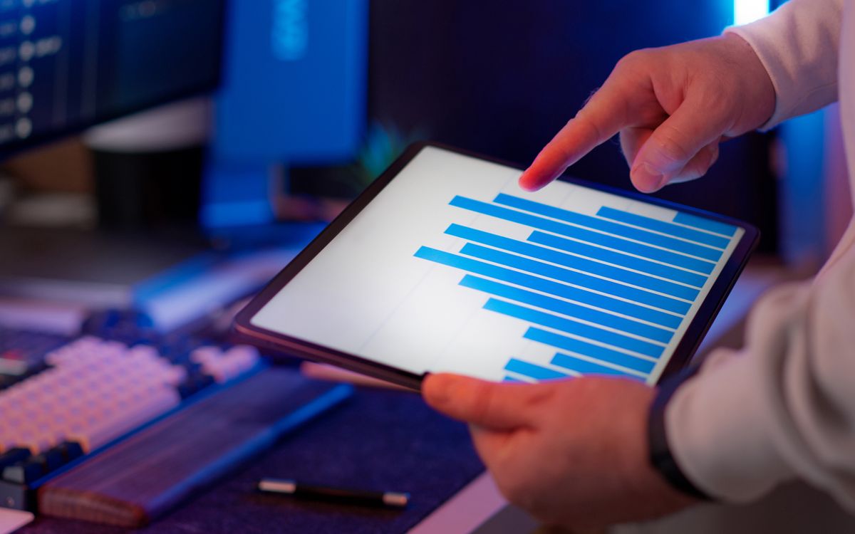 Close-up of a hand analyzing a performance chart on a tablet