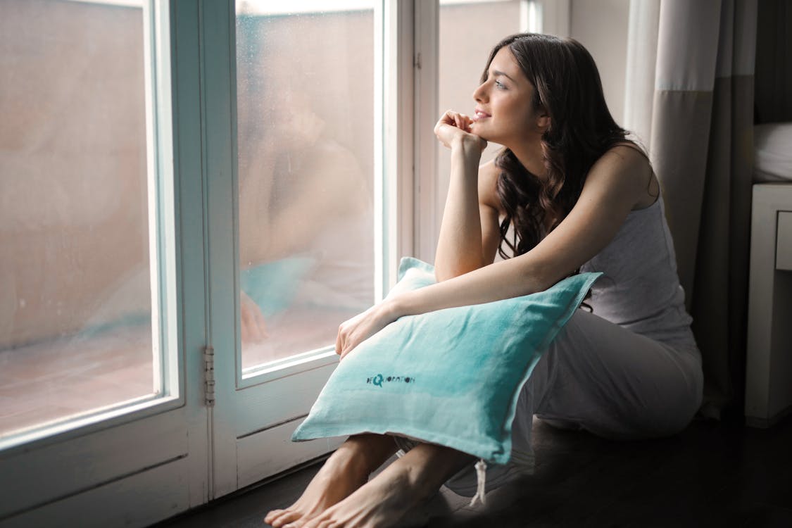 Free Woman Holding Teal Pillow Stock Photo