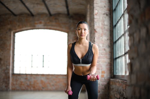 Premium Photo  A woman in a black sports bra top and black leggings posing  for a picture in a city at night time wi