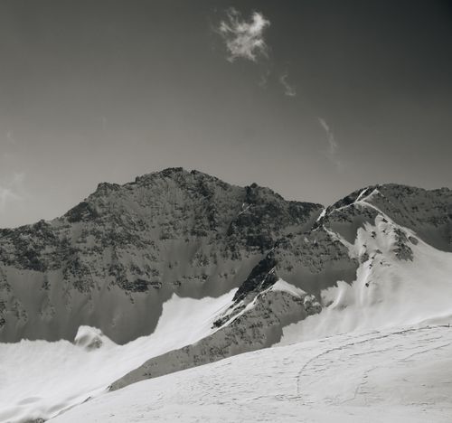 Free Stunning black and white photograph of a snow-covered mountain range under a clear sky. Stock Photo