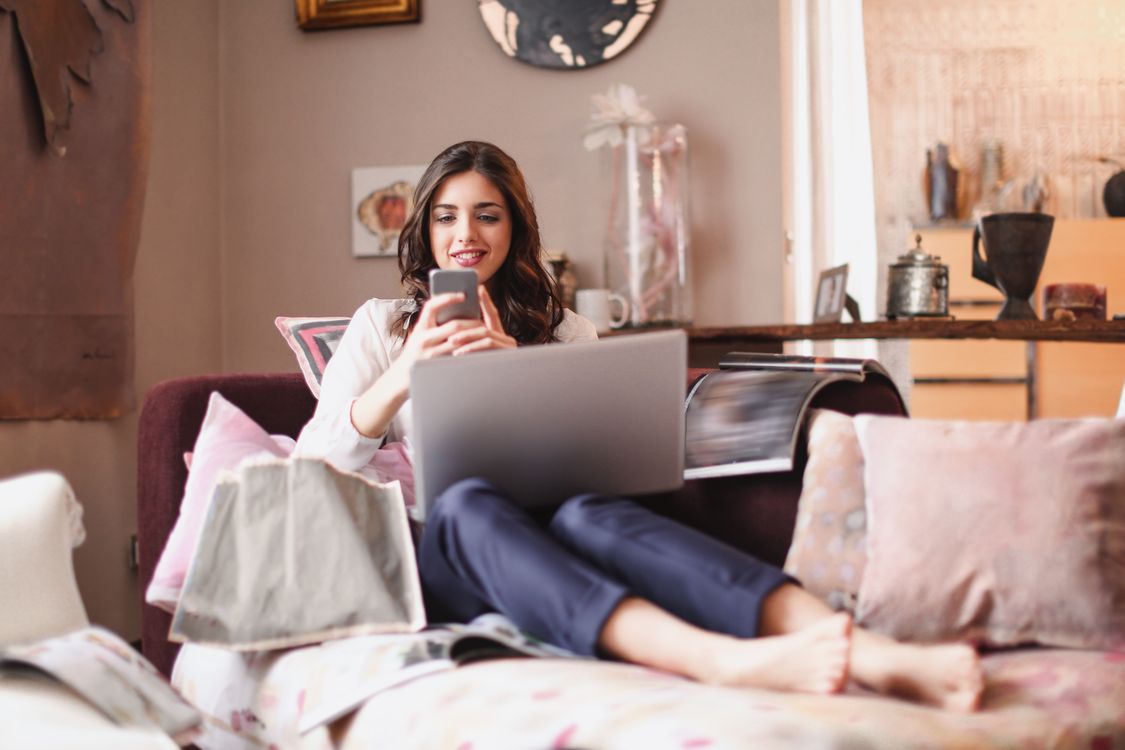 Woman Using Smartphone While Lying on Couch