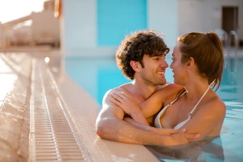 Free Man and Woman Embracing While on Swimming Pool Stock Photo