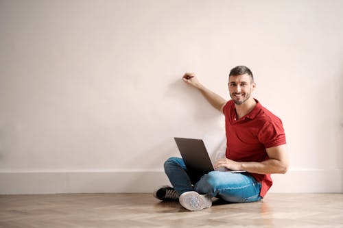 Man Smiling While Sitting on Floor