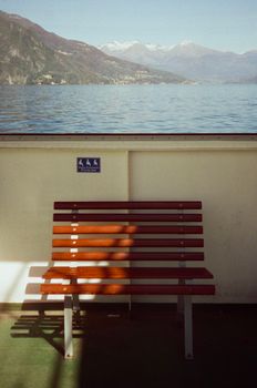 Peaceful ferry ride on Lake Como with a view of mountains in Lombardy, Italy.
