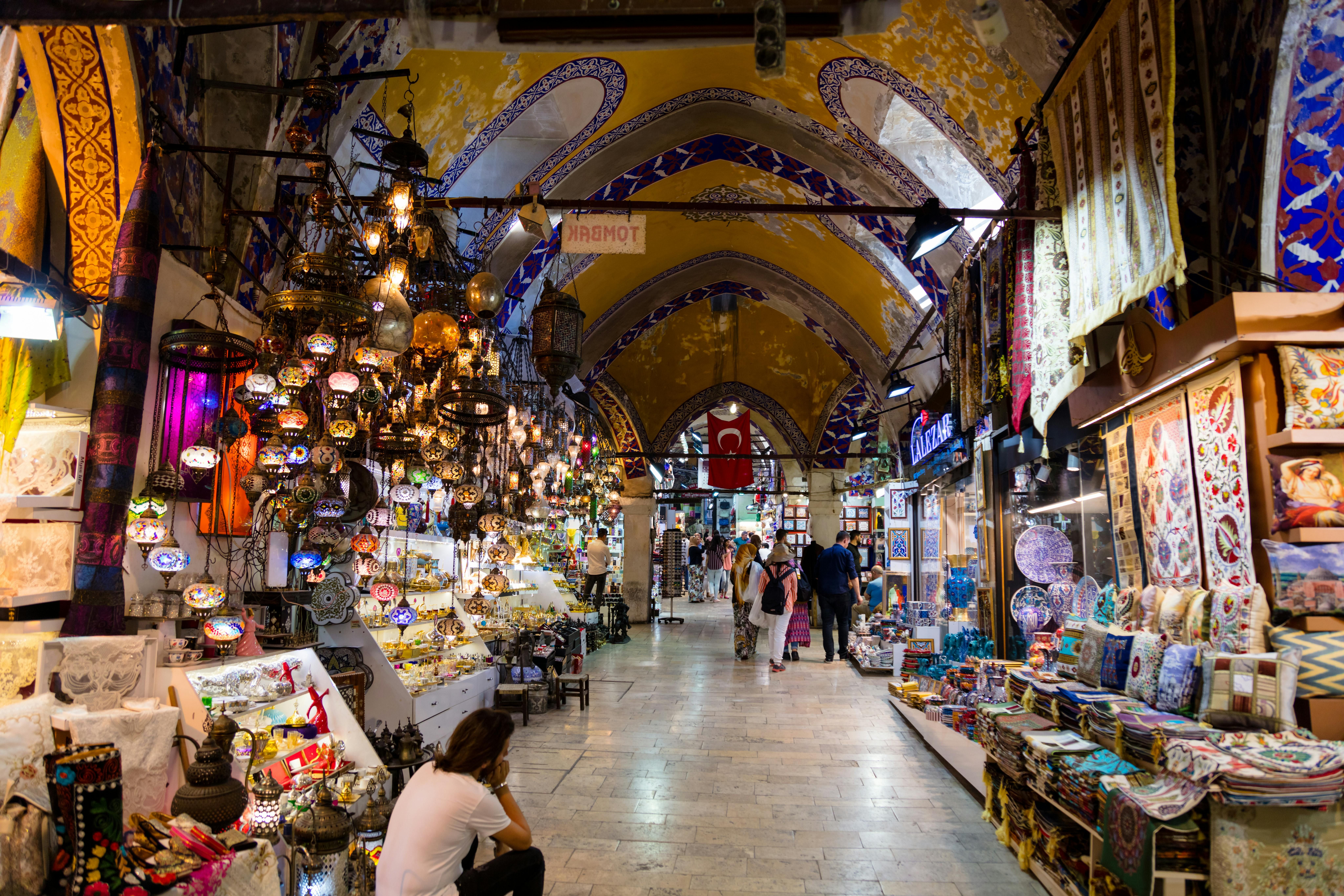 Colorful stalls and lights in Istanbul's iconic Grand Bazaar, bustling with shoppers.