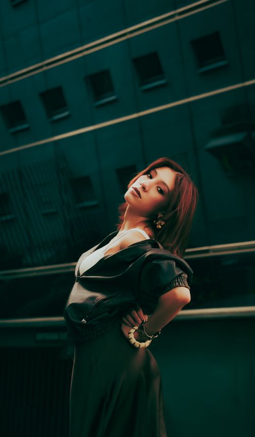 Free Fashionable woman posing confidently against urban backdrop, showcasing contemporary style. Stock Photo