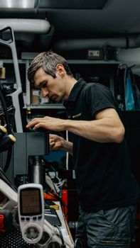 A focused technician repairing equipment in a cluttered workshop, showcasing industrial work.