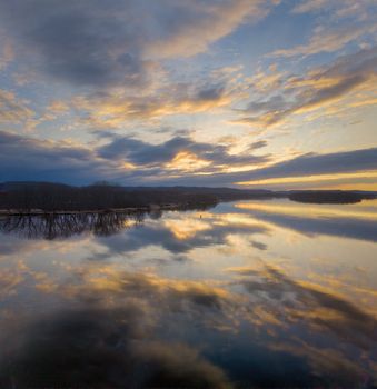 Stunning sunset reflecting on the water in Wabasha, Minnesota, showcasing vivid colors and dramatic clouds.