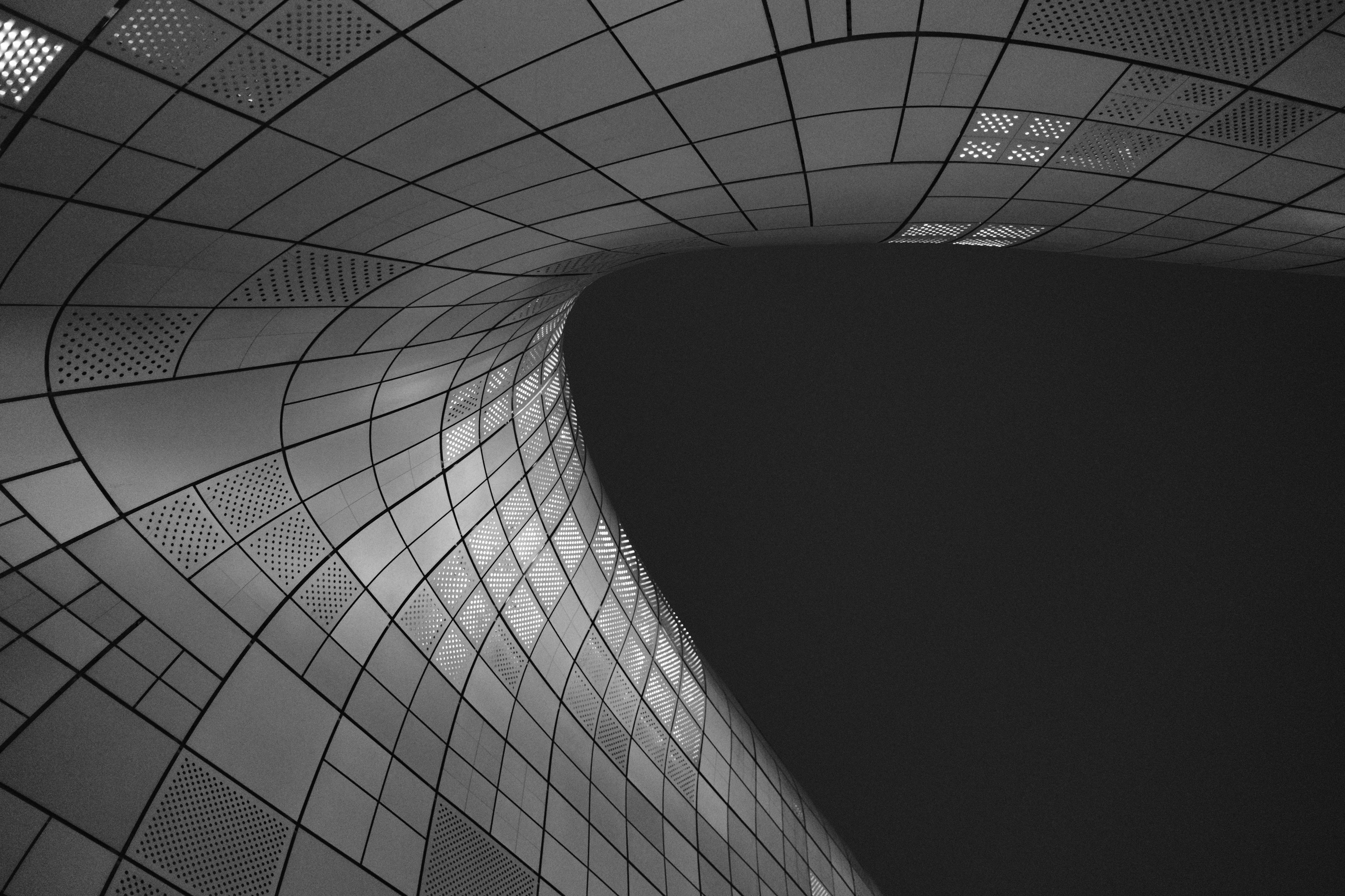 Curved architectural details of Dongdaemun Design Plaza in Seoul, captured in monochrome tones.