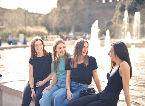 Free Photo of Women Laughing While Sitting Near Water Fountain Stock Photo