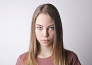 白色背景下一位表情严肃的年轻女子的特写