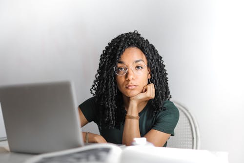 Serious ethnic young woman using laptop at home