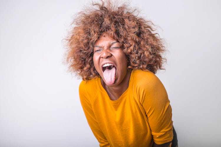 Grimacing Ethnic Woman With Tongue Sticking Out In Studio