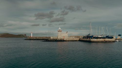 Free A tranquil view of Howth Lighthouse and marina against a cloudy sky. Stock Photo