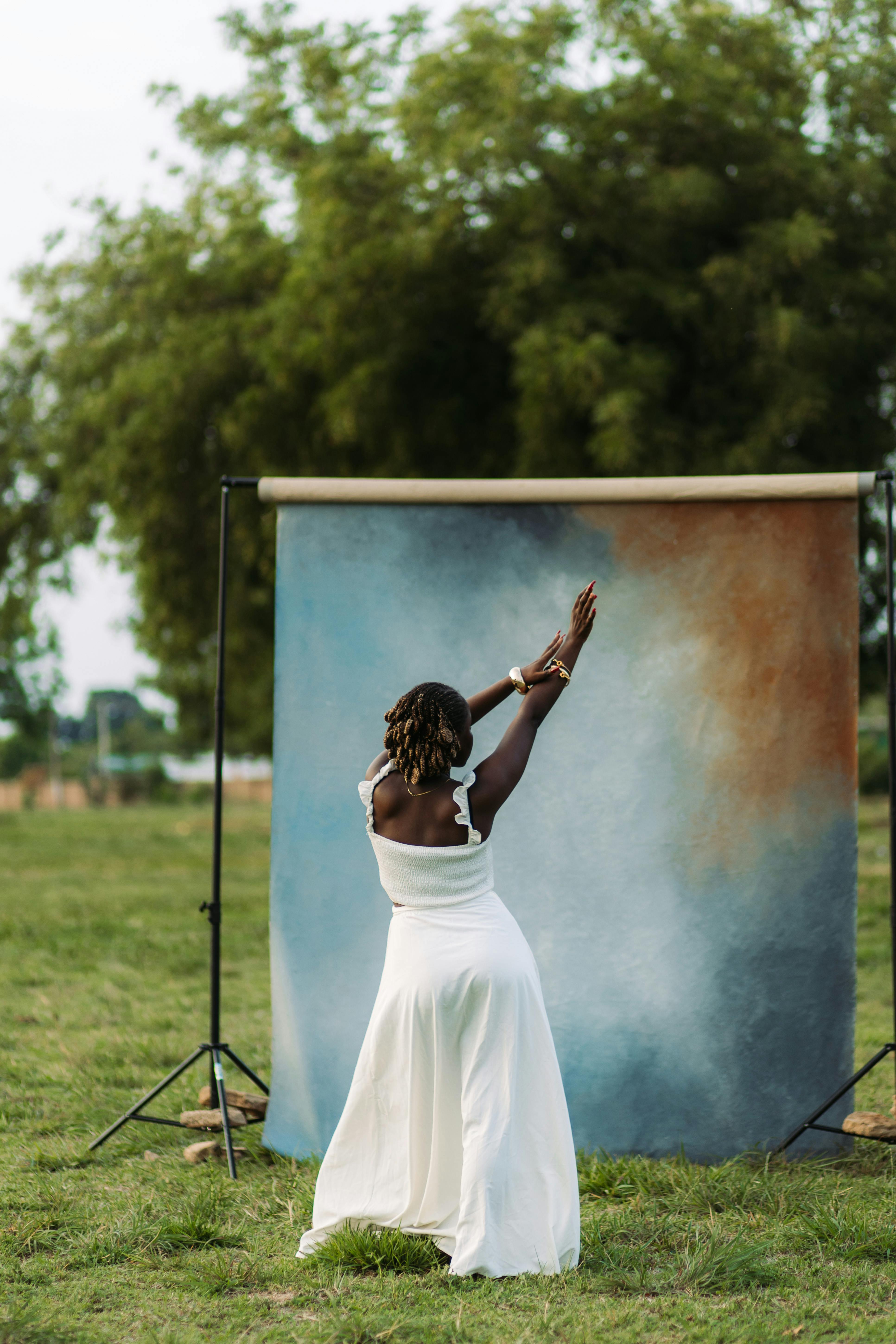 Captivating outdoor portrait of a woman in a white dress with a colorful backdrop.