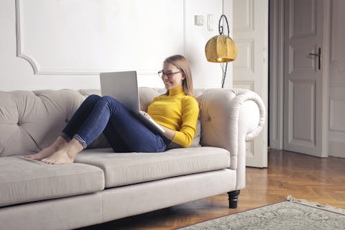 Free Woman in Yellow Long Sleeve Using Portable Computer Stock Photo