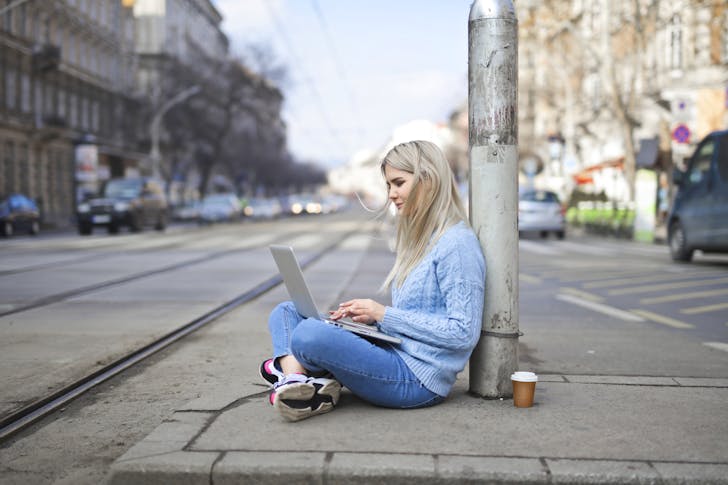 woman In Blue Sweater Typing On Computer laptop