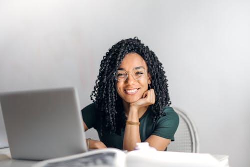 Feliz Mulher étnica Sentada à Mesa Com Um Laptop