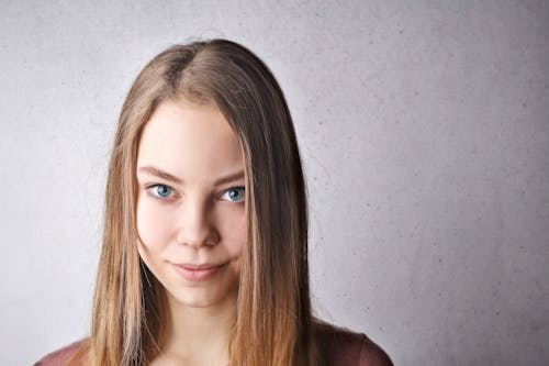 Portrait Photo De Femme Souriante En T Shirt Marron En Face De Fond Blanc