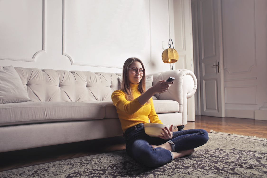 Free Young woman relaxing at home and watching movie Stock Photo