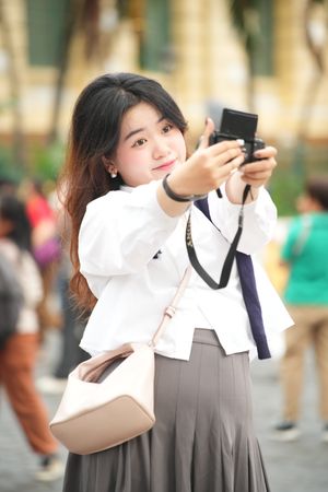 Woman smiling while taking a selfie outdoors, photo by Media Dung on Pexels