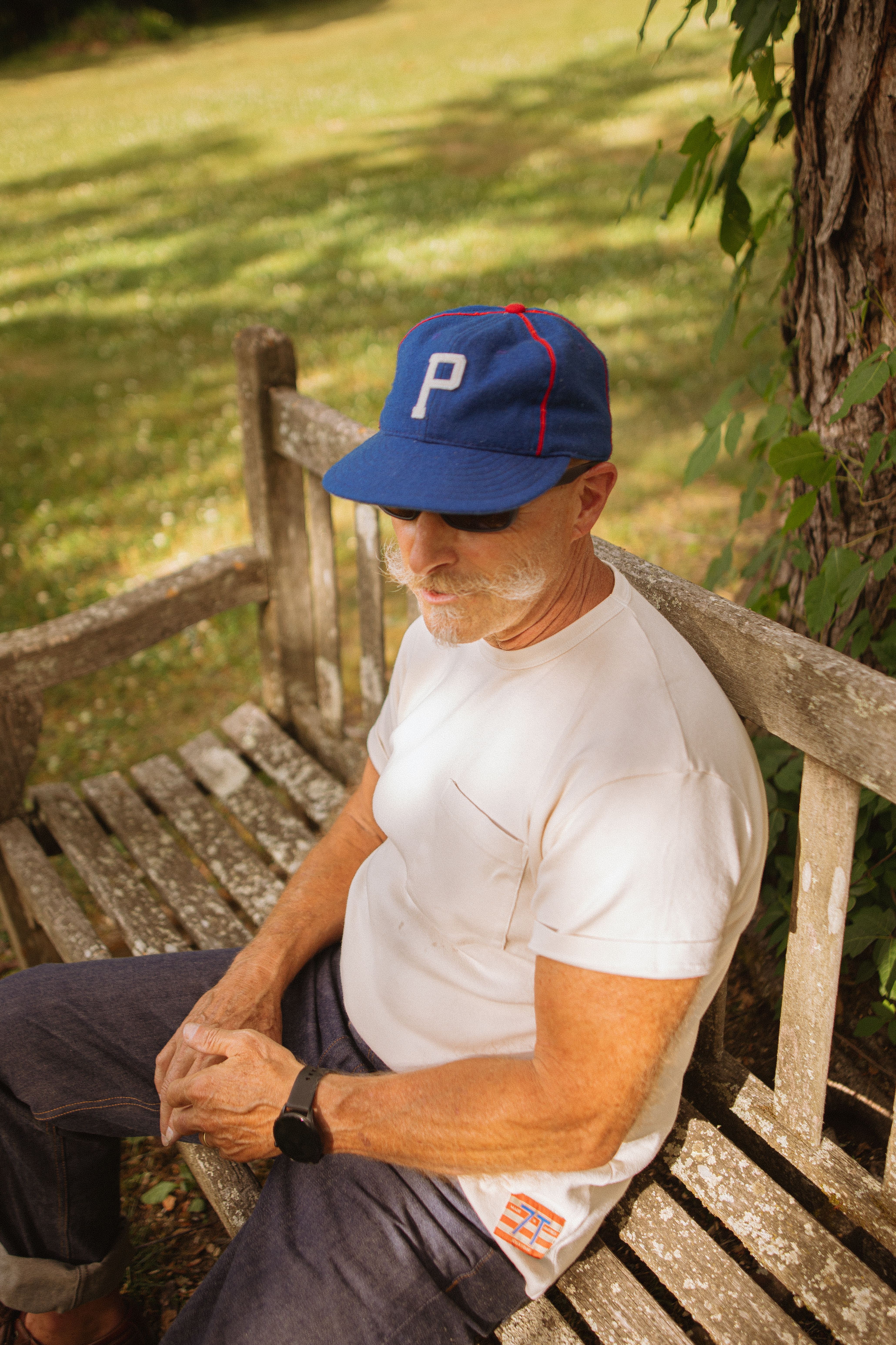 A man in casual menswear relaxing outdoors in Brevard, North Carolina.