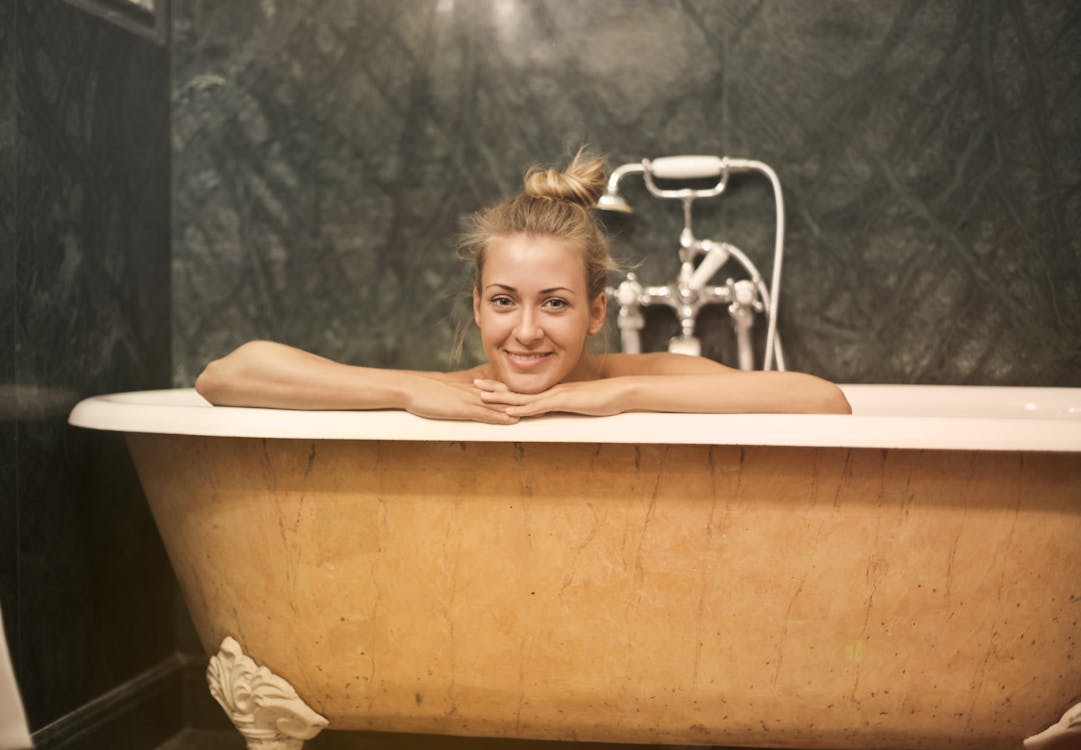 Free Photo of Smiling Woman Sitting in White Ceramic Bathtub Stock Photo