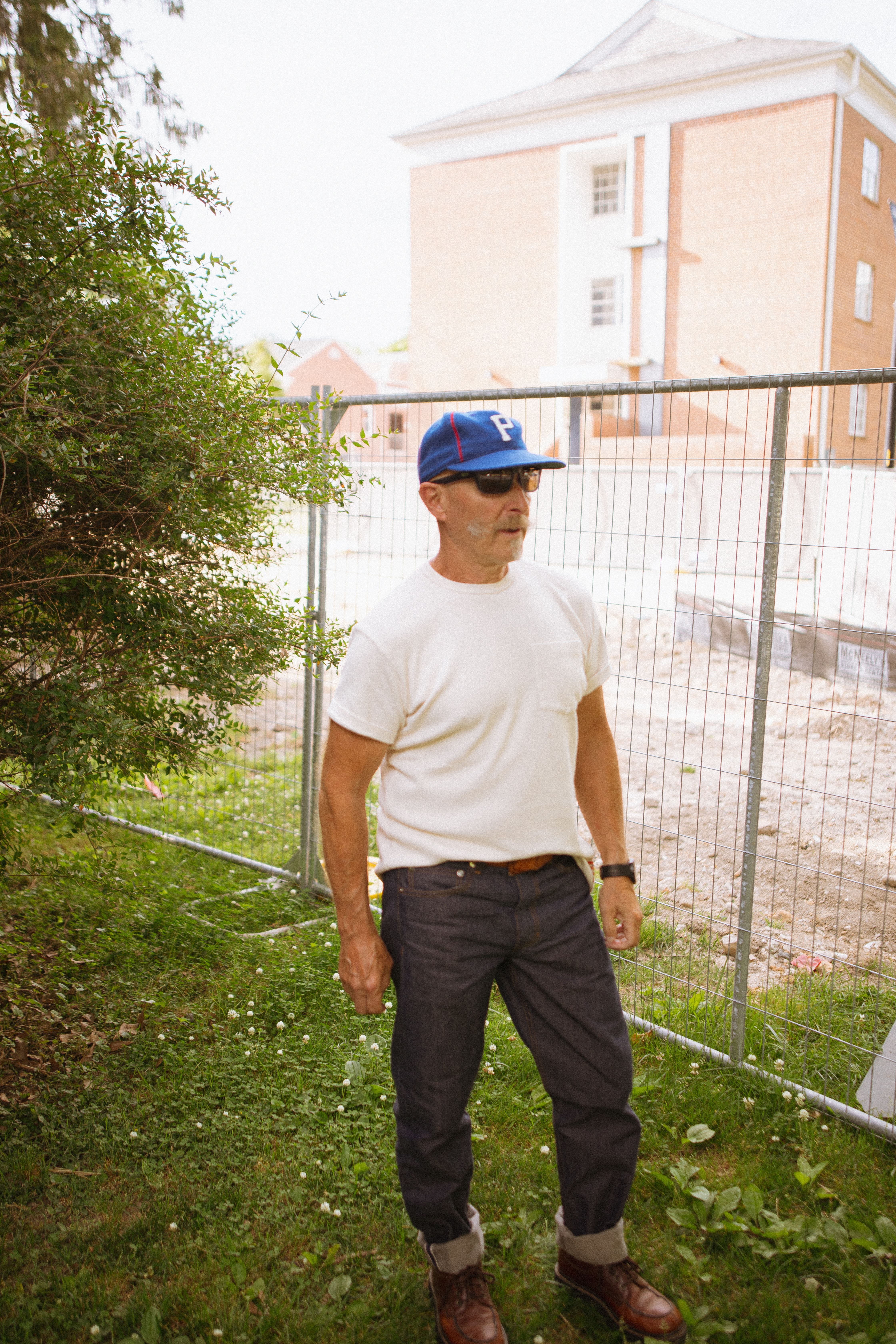 An outdoor portrait of a man in casual menswear, embodying rugged style.
