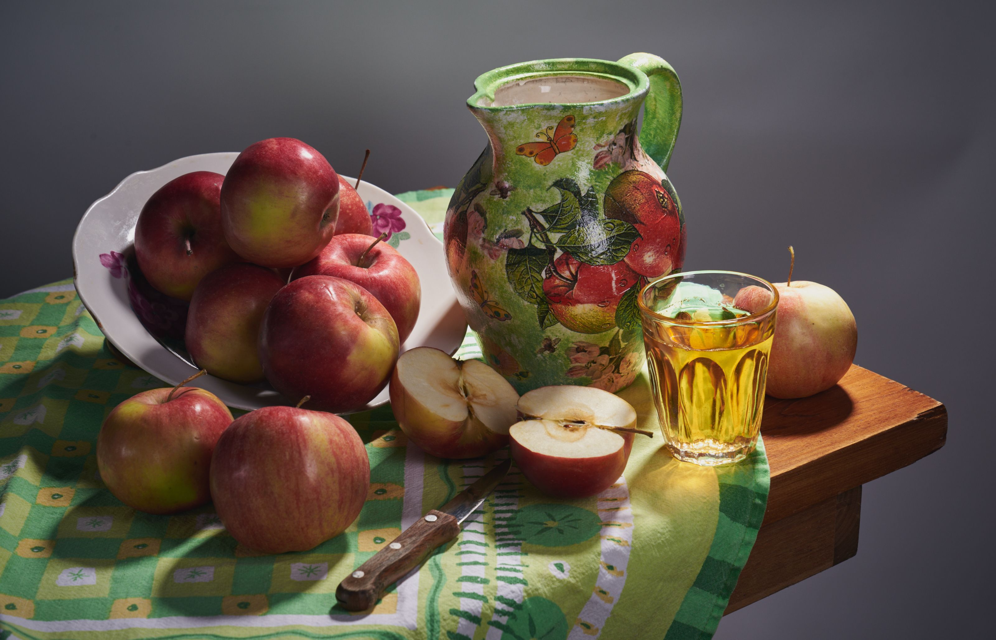 Glass of apple juice beside fresh apples