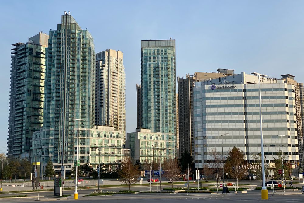 Photo of a city skyline featuring modern high-rise buildings with a clear blue sky.