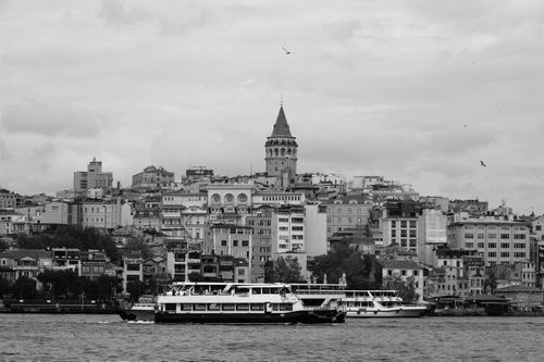 Free Black and white photo of Galata Tower with boats on the Bosphorus under a cloudy sky. Stock Photo