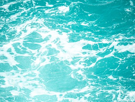A close-up view of turquoise ocean waves and white foam, capturing the dynamic and refreshing movement of the sea.