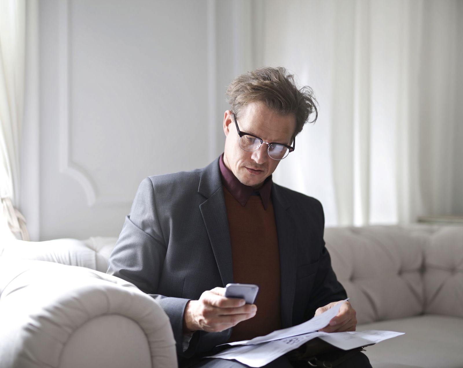 Client answering questions on his phone with documents beside him