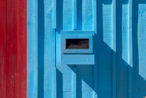 Free Abstract close-up of blue and red building facade with shadows creating depth. Stock Photo
