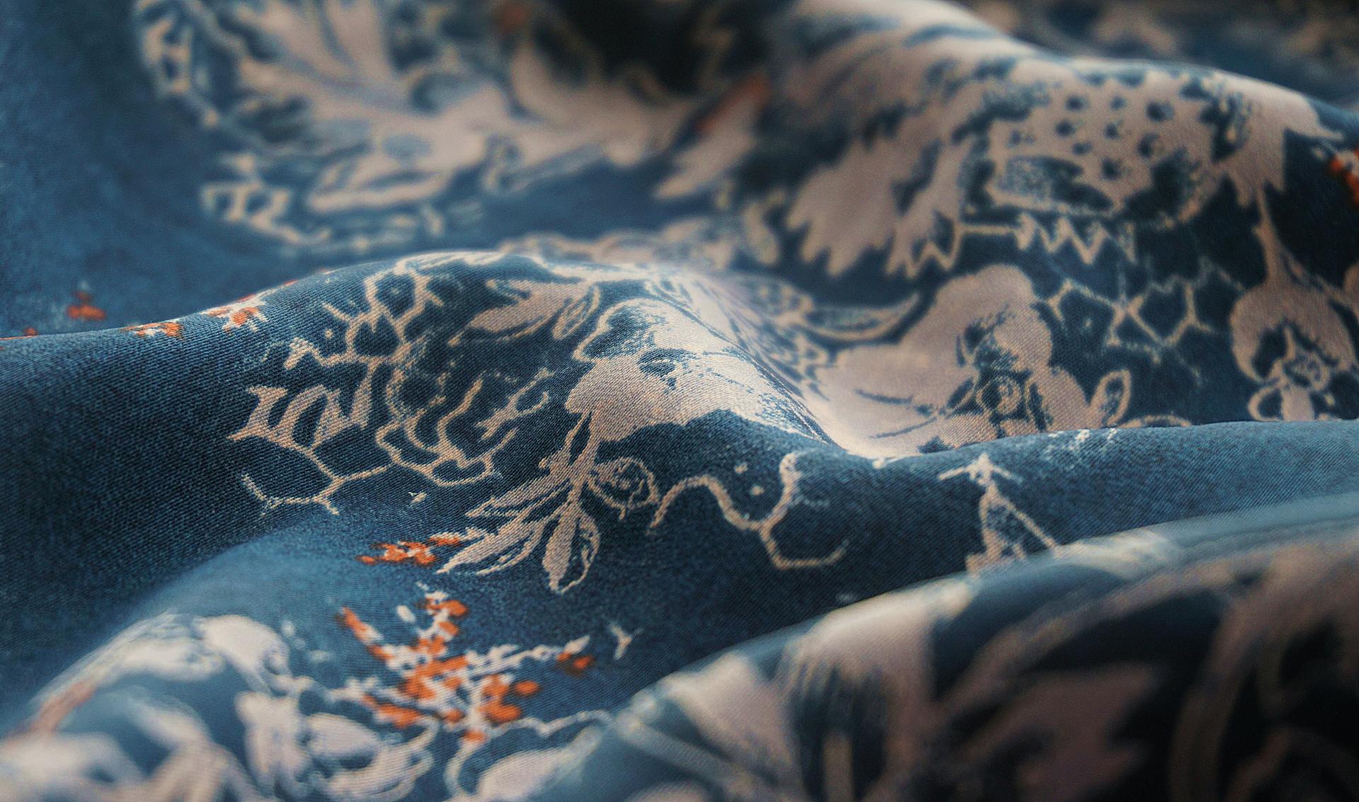 Close-up of a blue floral fabric showcasing intricate patterns and rich textures, perfect for textiles and design inspiration.