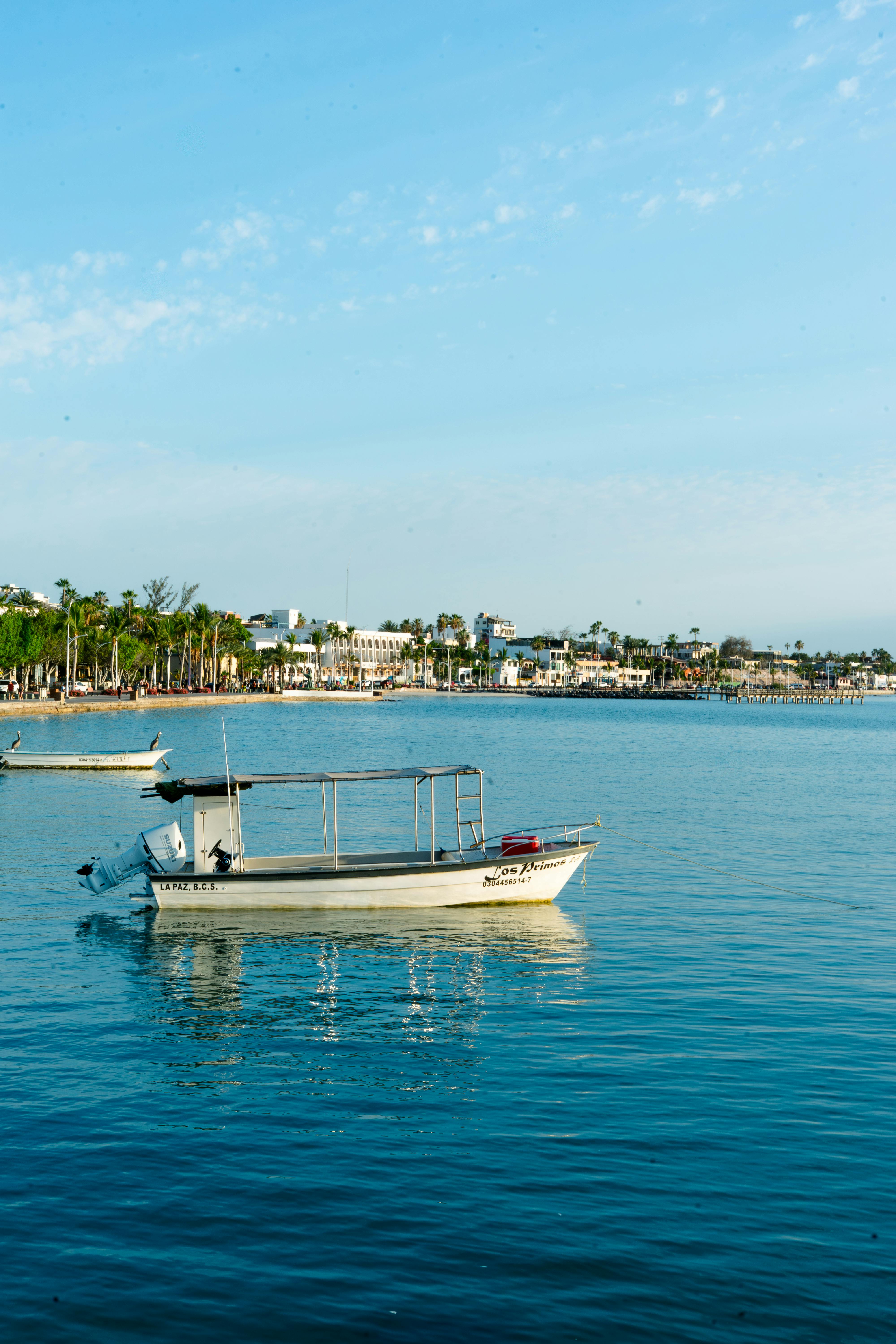 A peaceful dinghy floating in La Paz Bay with a cityscape backdrop in Baja California Sur, Mexico.