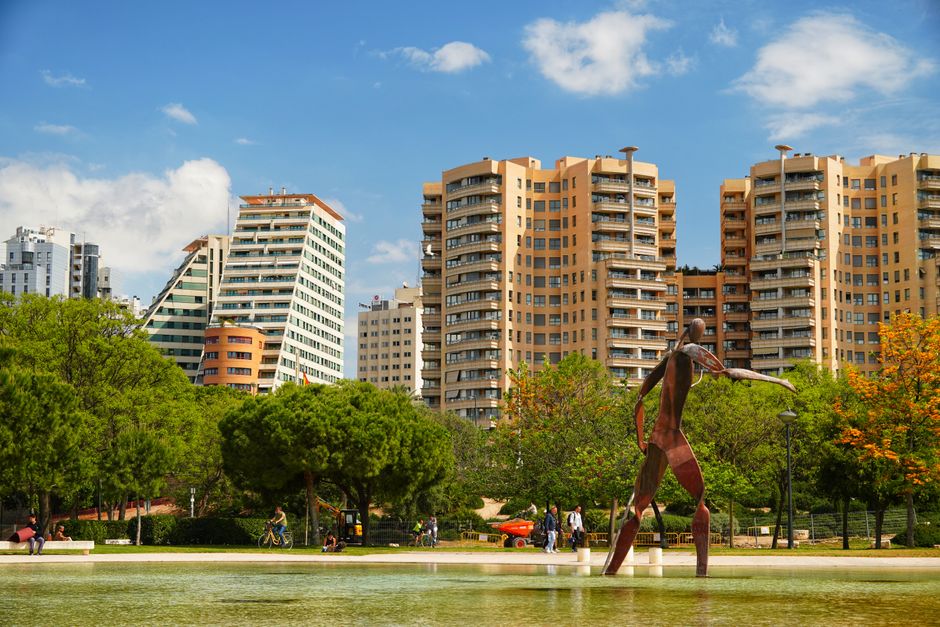 Vista panorámica de imponentes edificios y una llamativa escultura en un parque de Valencia.