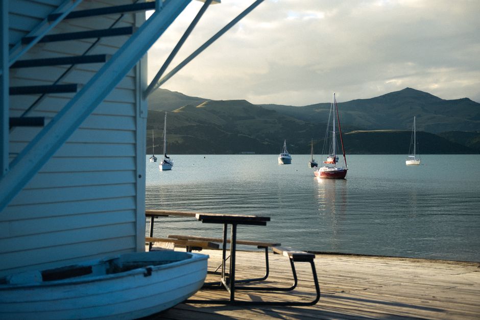 Photo by Tom Macret on Pexels Boats anchored peacefully in Akaroa Harbour with a mountainous backdrop in Canterbury, New Zealand.