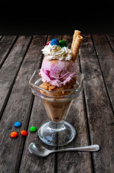 A vibrant ice cream sundae with three flavors, whipped cream, and candies.