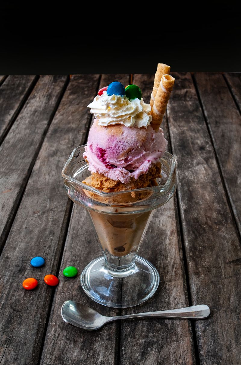Colourful triple scoop ice cream sundae with toppings at a party