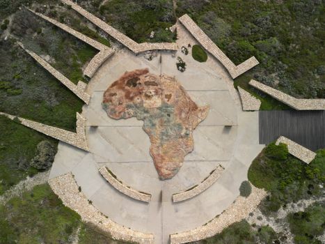 A striking aerial view of an Africa map sculpture surrounded by lush greenery.