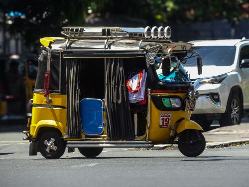 Free Colorful tuk-tuk amid Manila traffic illustrates lively street culture. Stock Photo