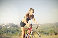 一位意志坚定的女子在风景优美的道路上，一边骑车锻炼，一边听着音乐